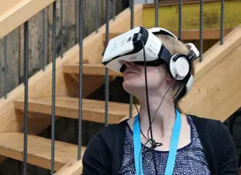 Eine Teilnehmerin trägt eine Virtual Reality Brille und schaut nach links.